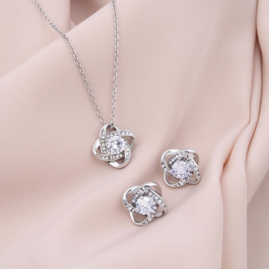 Love knot necklace and earring gift set on soft fabric