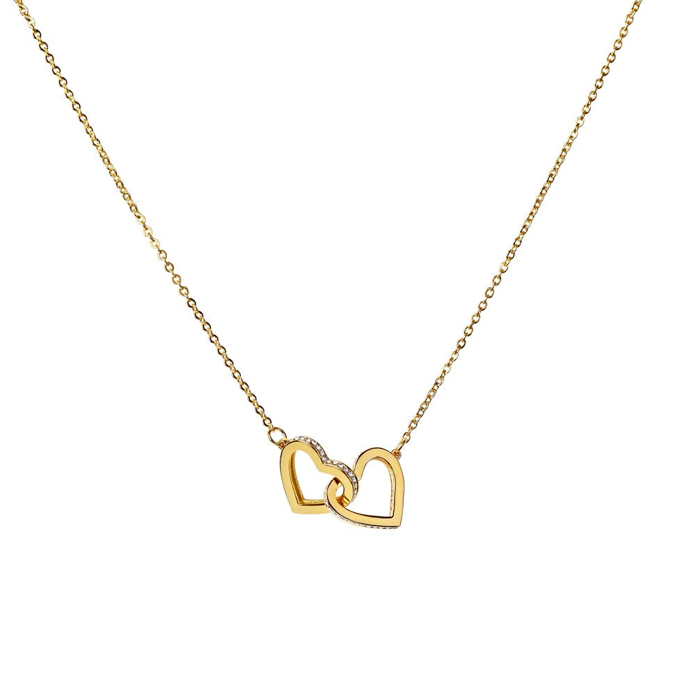 Gold interlocking hearts necklace on a white background